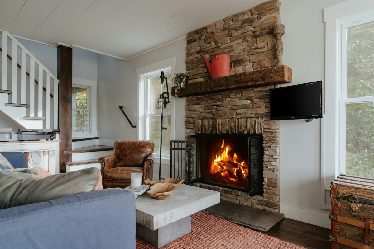 White living room with a sofa beside a lit fireplace
